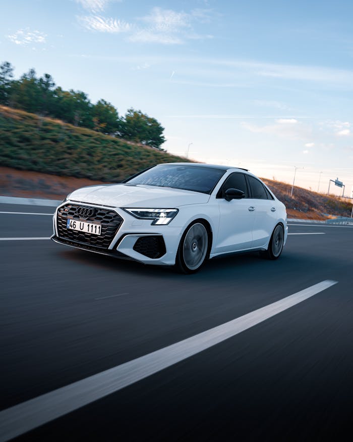 White Audi car driving on a highway in Ankara, Türkiye at sunset.